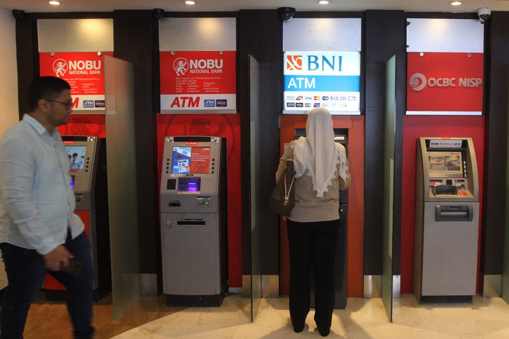 Warga menggunakan fasilitas anjungan tunai mandiri (ATM) di salah satu pusat perbelanjaan di Jakarta