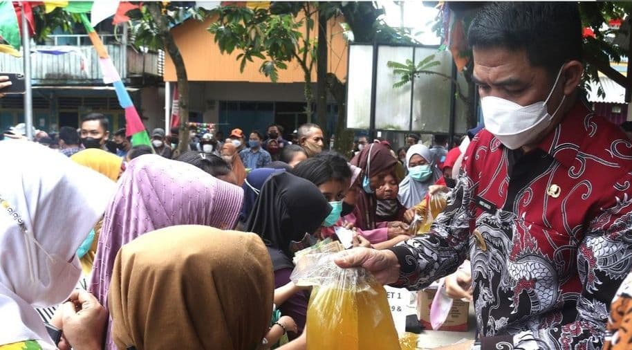 Wali Kota Samarinda Andi Harun melayani warga yang antre membeli minyak goreng dalam operasi pasar.