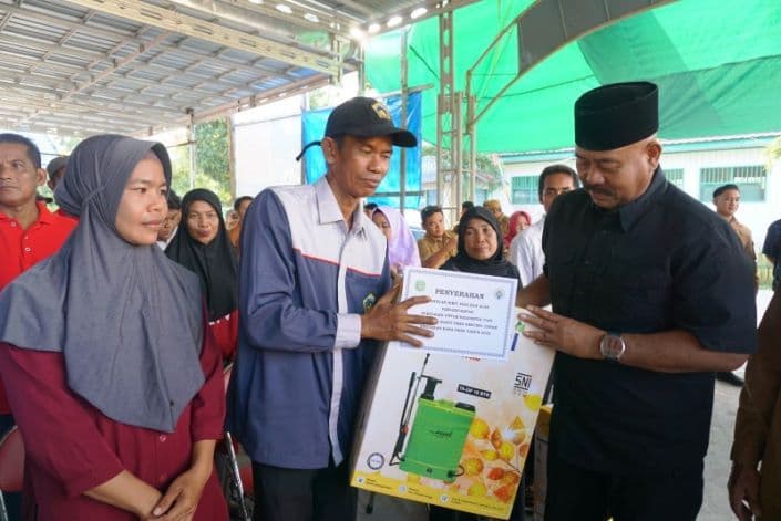 Bupati Kutai Kartanegara, Edi Damansyah, menyerahkan bantuan dan honor pengurus RT di Desa Genting Tanah.  (Foto: Robi Sugiarto/ibukotakini.com)