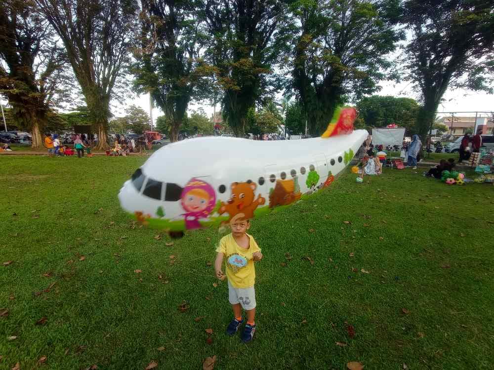 Potret seorang anak bermain di Lapangan Merdeka dengan latar belakang PKL. Wacana mengembalikan fungsi Lapangan Merdeka muncul terkait kondisi kawasan yang semakin tidak terkendali.  (FOTO: ARSIP IBUKOTAKINI.COM)