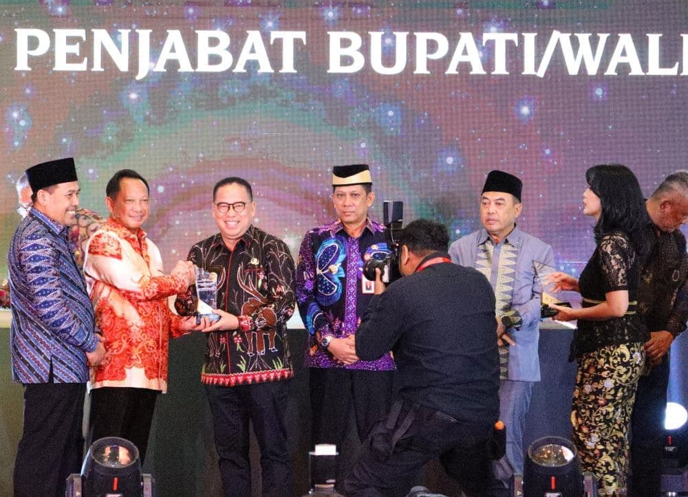 Mendagri Tito Karnavian menyerahkan penghargaan kepada Pj Bupati PPU, Makmur Marbun.