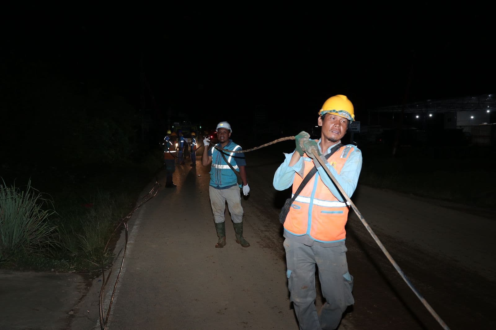 Petugas PLN melakukan penarikan jaringan listrik di tengah kegelapan untuk memulihkan pasokan listrik yang terdampak di Tapanuli Tengah