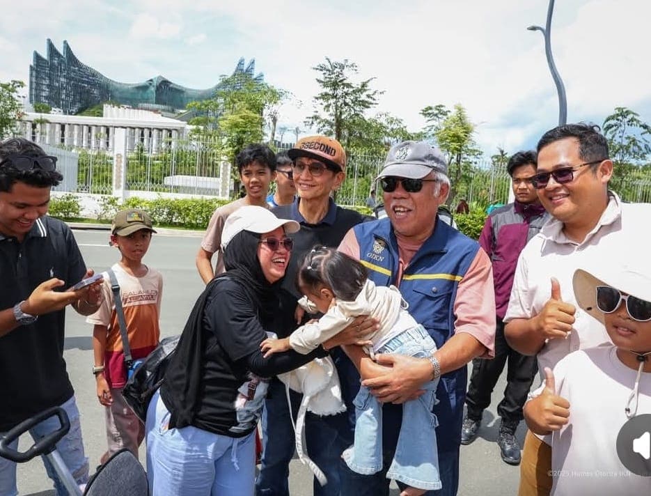 Kepala Otorita IKN Basuki Hadimuljono menggendong anak pengunjung di depan Istana Garuda IKN.