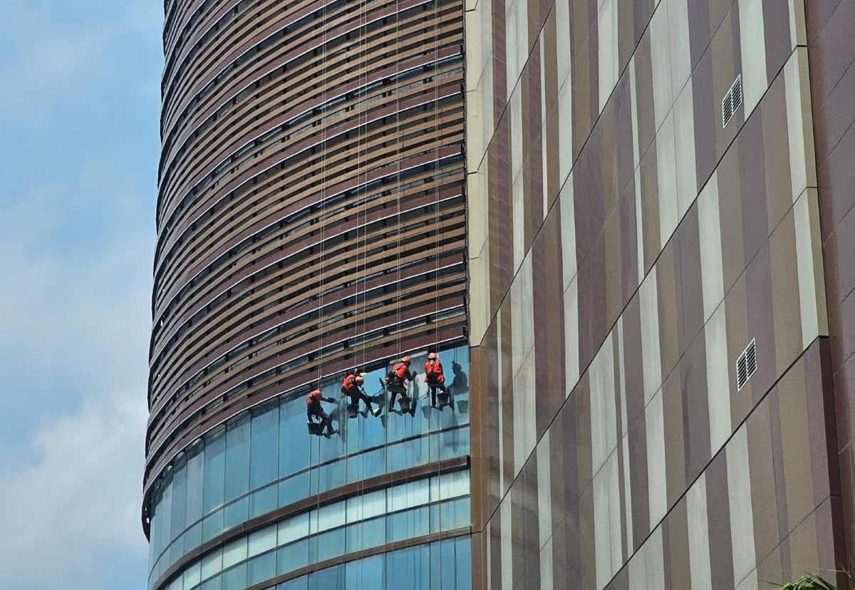 Pekerja membersihkan kaca di salah satu tower apartemen Borbeo Bay Residence Balikpapan. Pengembang kawasan multiguna itu bakal menggelar RUPS  akhir bulan ini. 