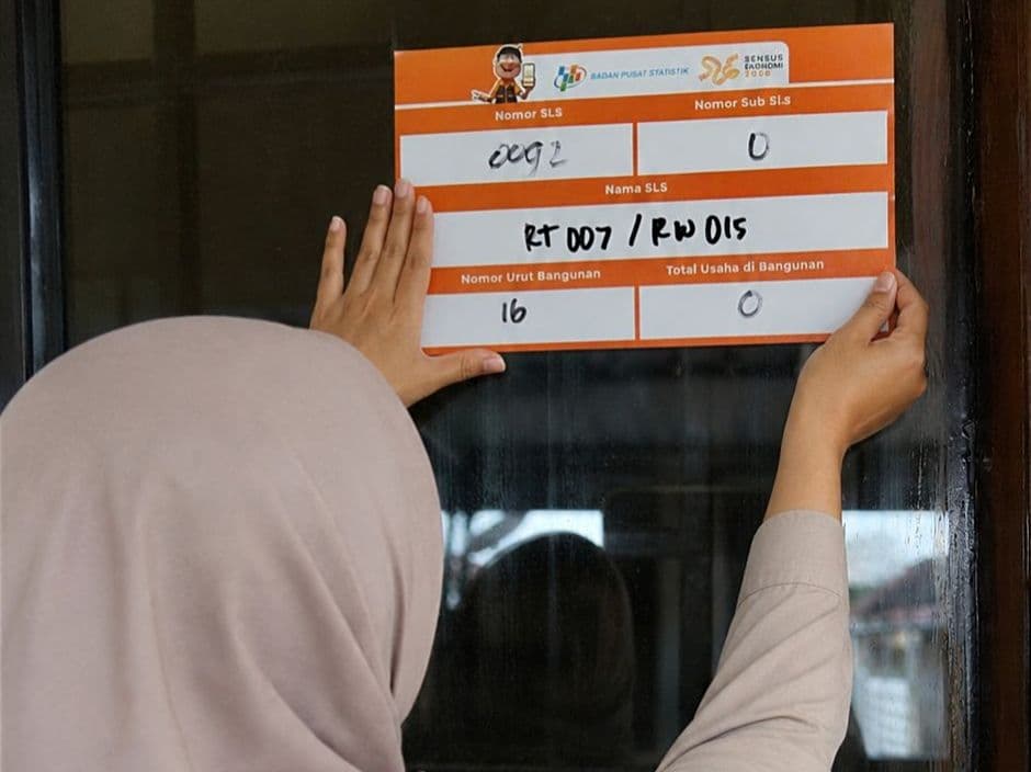 Petugas Sensus Ekonomi 2026 memasang stiker di rumah warga yang selesai disensus. 