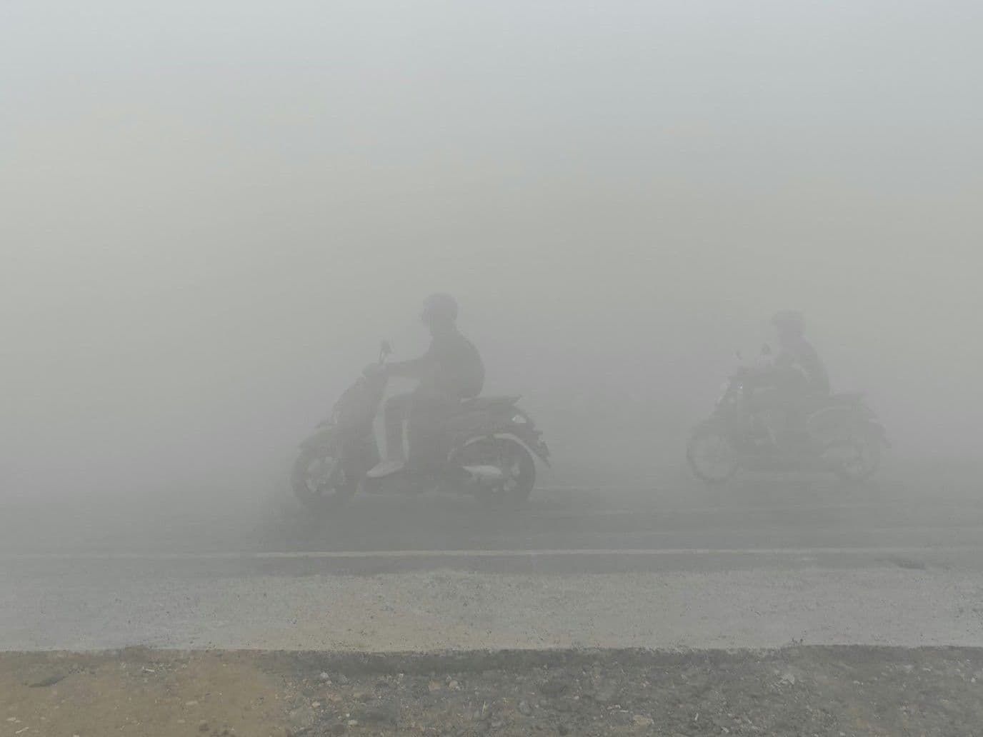 Pengendara melintas di jalan yang dipenuhi asap di  Kota Pontianak, Kalimantan Barat, baru-baru ini. 