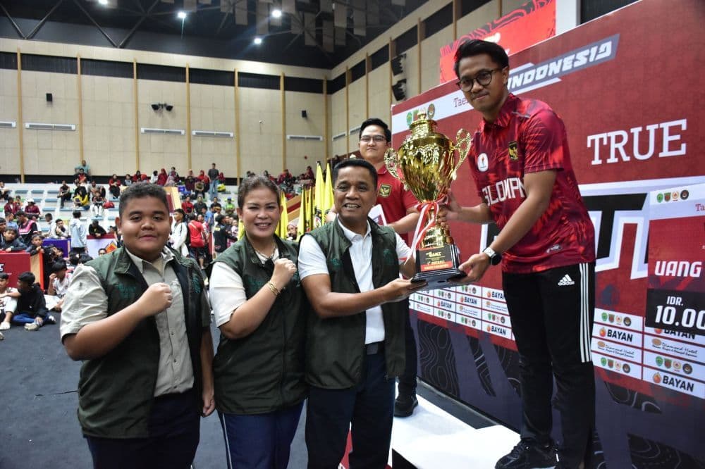 Brigjen TNI Anggara Sitompul menyerahkan piala kepada pemenang utama Turnamen Taekwondo Terbuka Borneo 2025. (Penrem)