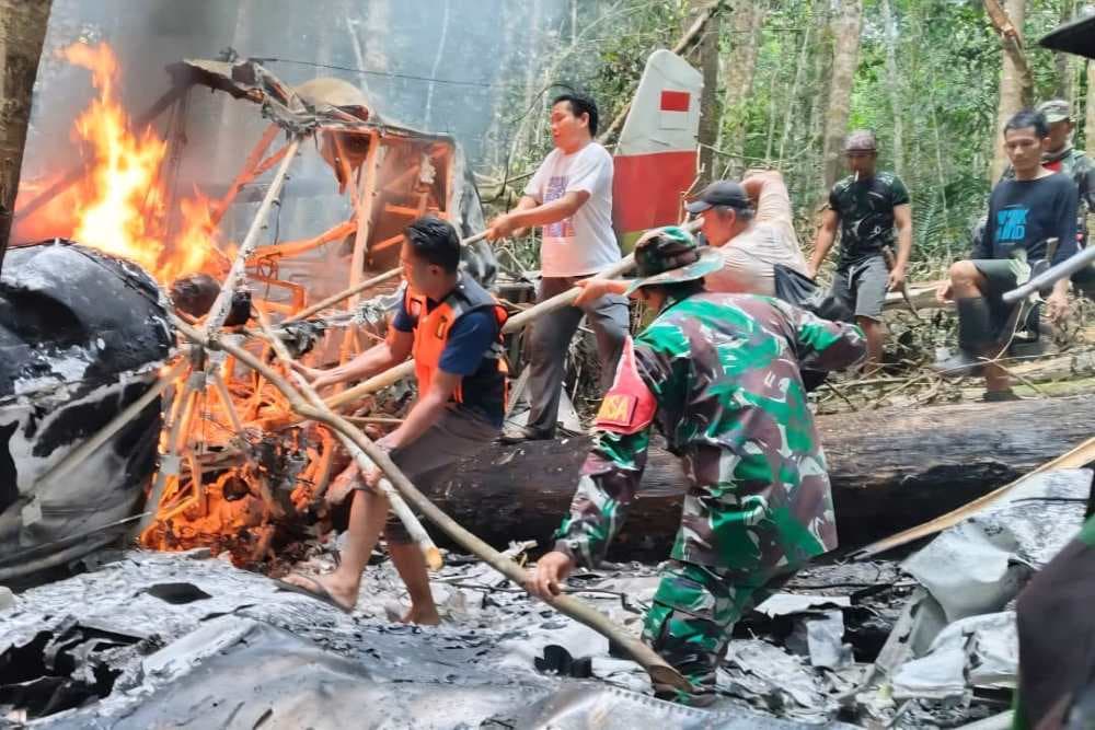 Personel Koramil 0911-06/Krayan berjibaku memdamkan api di atas puing-puing pesawat. (Foto: Pendam VI/ Mulawarman)